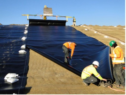 Staffs applying geomembrane